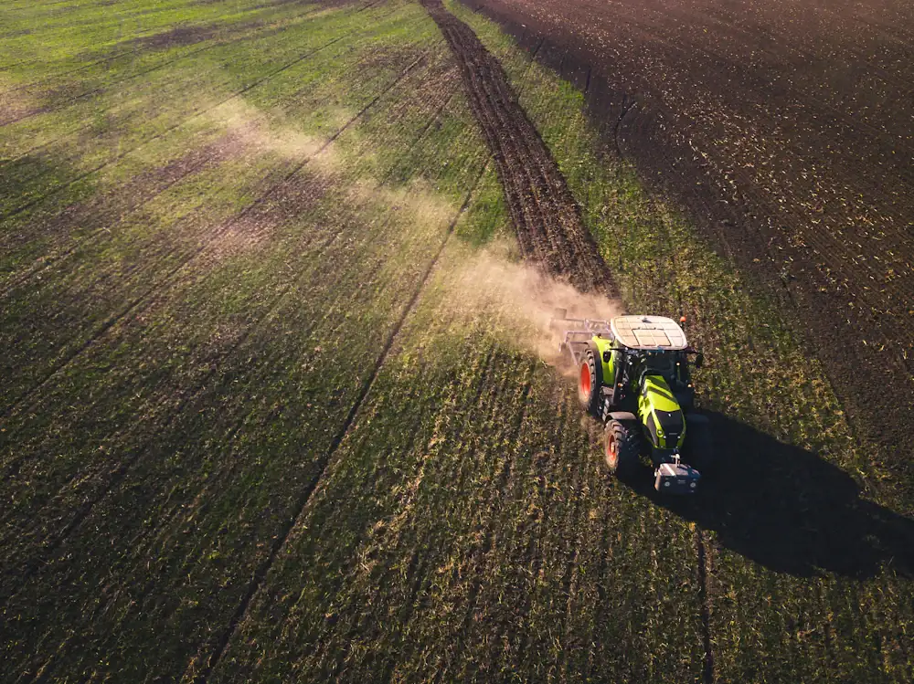 Vista aérea de un tractor que trabaja un campo de cultivo